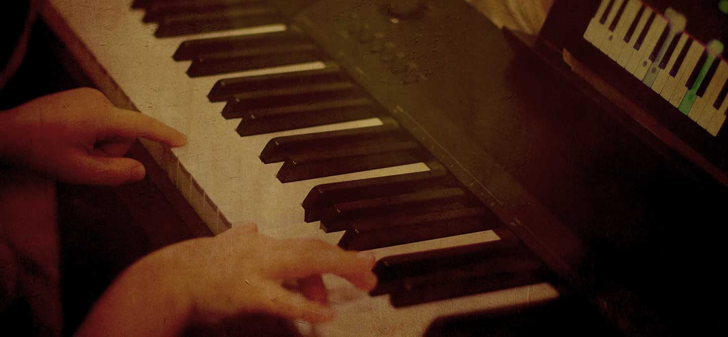 Hands playing a piano keyboard